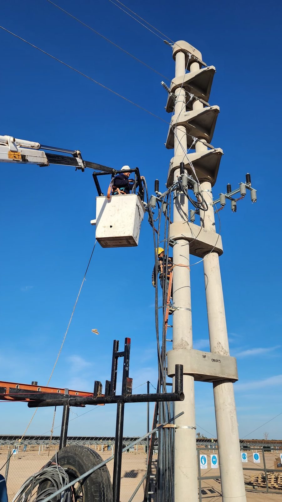Trabajo en altura sobre poste de hormigón con línea eléctrica